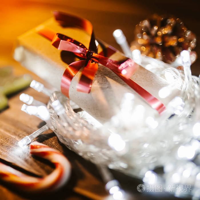 礼品盒上的木桌上有浅花环。圣诞假期背景