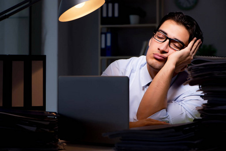 年轻的生意人加班工作到深夜照片