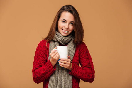 快乐的白种女人穿着毛衣喝着热茶