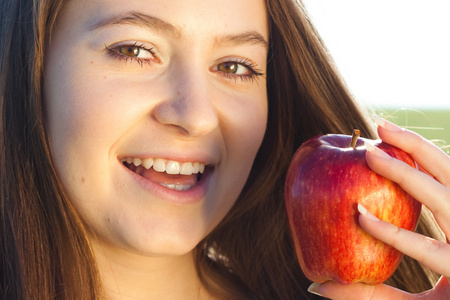 一位美丽的年轻女子与苹果户外肖像。