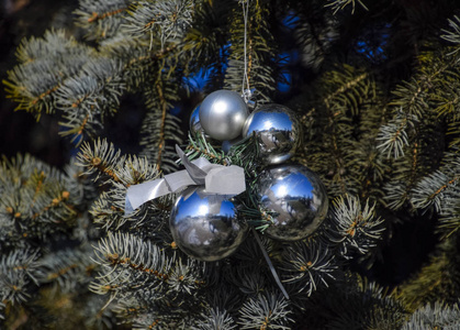 圣诞圣诞树上的金属丝玩具球和其他装饰品站在露天。装饰新年树