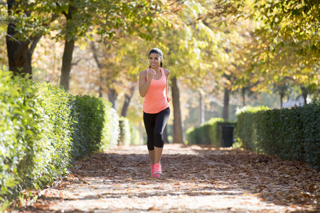 有吸引力和快乐的跑步运动员在秋季运动服运行