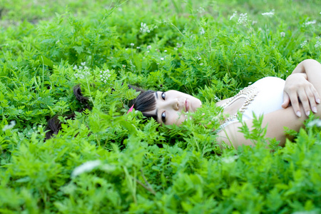 一个美丽的女孩躺在花丛中的特写肖像