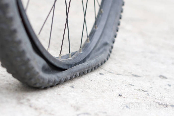 在水泥路面上有扁平轮胎的自行车车轮