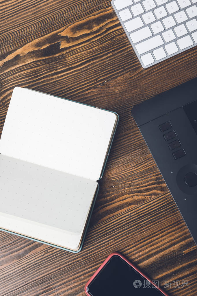 空白打开笔记本,智能手机,图形板和计算机键盘的顶部视图
