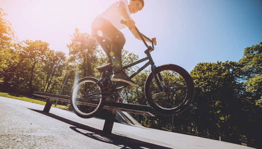 年轻的小轮车车手在 skatepark 表演把戏