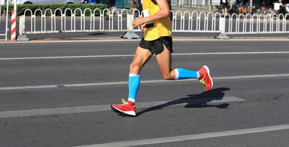 马拉松长跑运动员的腿在城市路