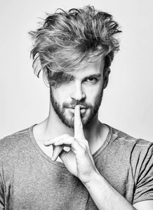 英俊的男人做嘘手势照片