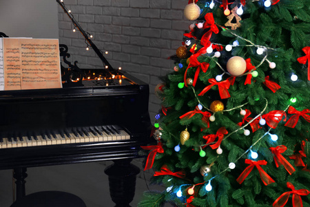 美丽的钢琴和圣诞树在房间里