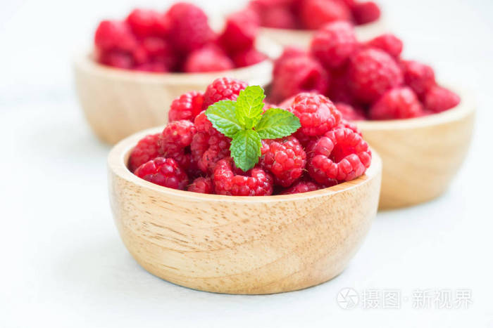红rasberries 果在木碗桌上