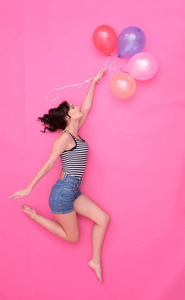 年轻女性正在用气球跳舞
