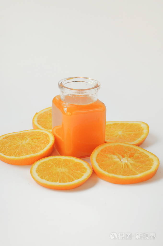 一瓶橙汁白色背景上有橙片维生素