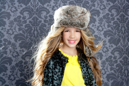 穿着冬豹外套和皮帽的儿童时装女孩