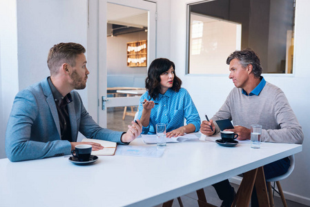 在现代的办公室开会的同事照片