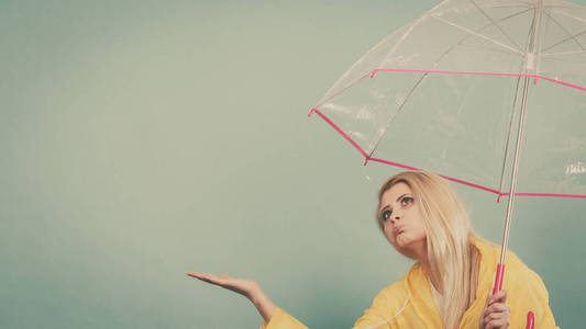 女人穿着雨衣打着伞检查天气图片