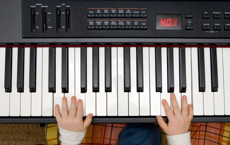 男孩子们手拿电子钢琴或键盘