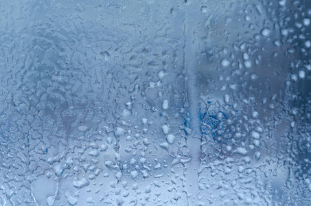 窗玻璃背景下的雨滴和冰冻水图片