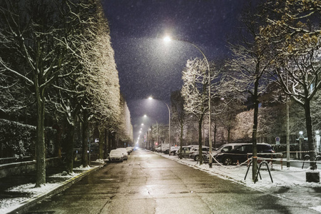 晚上在法国城市下雪, 空荡荡的街道, 覆盖着雪地车
