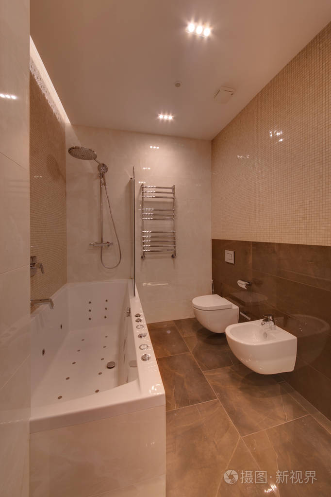 浴室配有大理石地板和小瓷砖的按摩浴缸