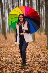 五颜六色的雨伞穿过森林的女人