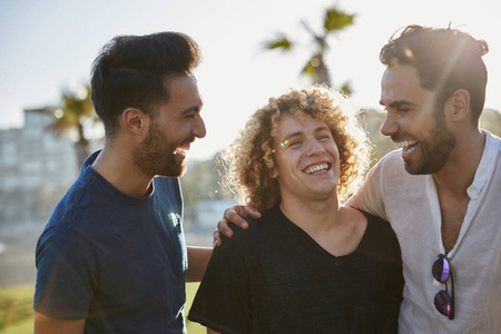 三男性朋友一起站立外面笑