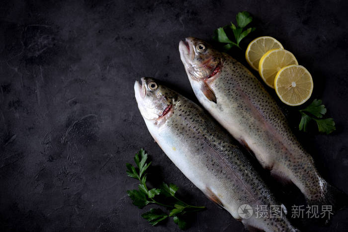 黑色背景的有机生鲜鳟鱼鱼顶部视图