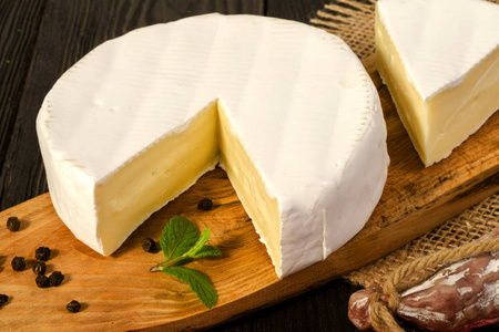 绕卡门培尔奶酪奶酪切成薄片，在木制的板和 fuet sausa