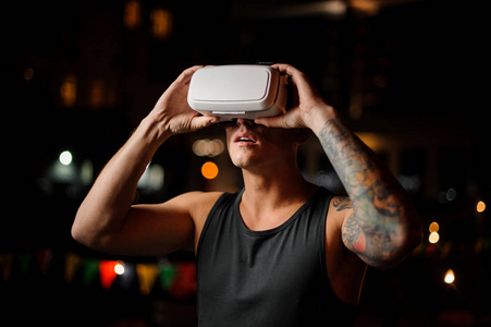 夜晚的城市背景下的虚拟现实技术的眼镜的男人