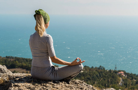 坐在山顶莲花姿势瑜伽女人照片