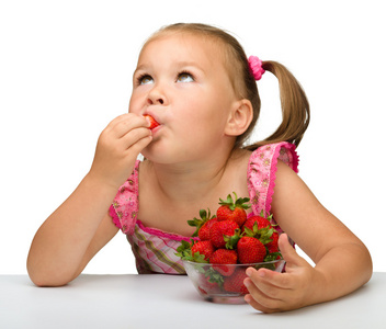 快乐的小女孩吃草莓