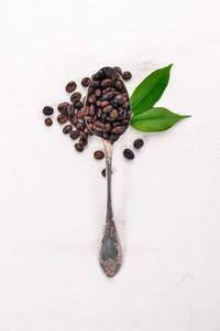 咖啡豆用勺子躺在木制的背景上。顶部视图。复制空间