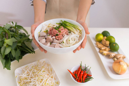 女厨师拿着碗与传统越南汤粉, 肉, 米粉