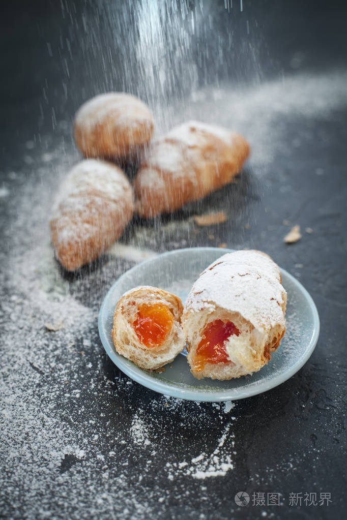 四带水果馅的羊角面包, 在深灰色的背景上洒上糖粉