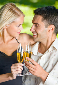 年轻的幸福夫妇在户外庆祝香槟