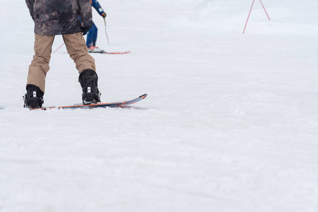 滑雪和滑雪板爱好者骑在滑雪坡上