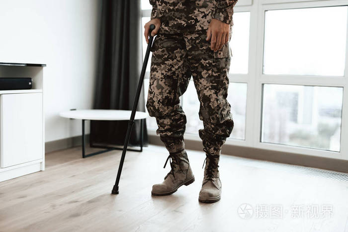 一个残废的士兵拄着拐杖他从轮椅上起身走了