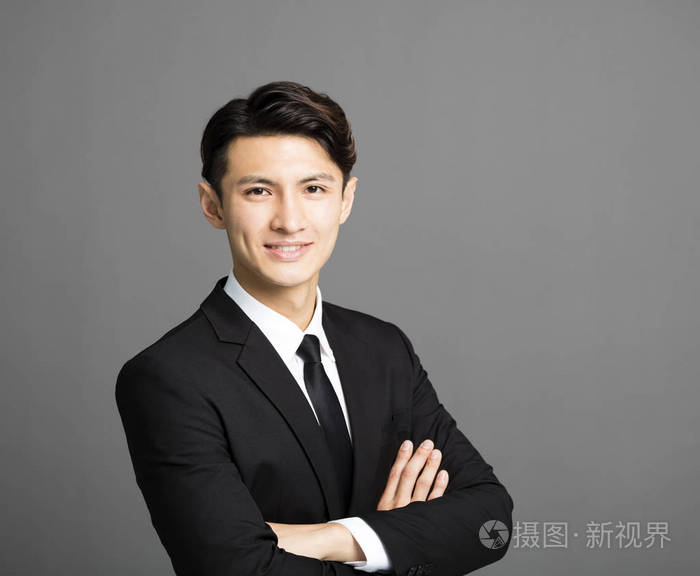 灰色背景的年轻微笑的生意人照片-正版商用图片030yok-摄图新视界