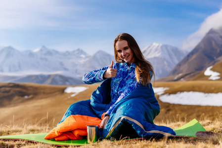 愉快的妇女游人坐在山的背景