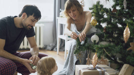 幸福家庭与小女儿装饰圣诞树在家