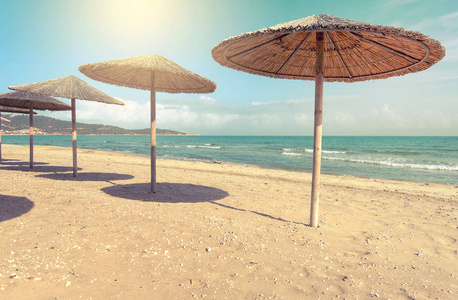 Sarti, 希腊, 没有人的夏天海滩, 海和沙子, 空的海和海滩背景用秸杆雨伞