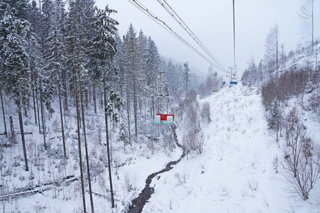 走到滑雪跑道。椅子上的电梯在积雪覆盖的树上升起