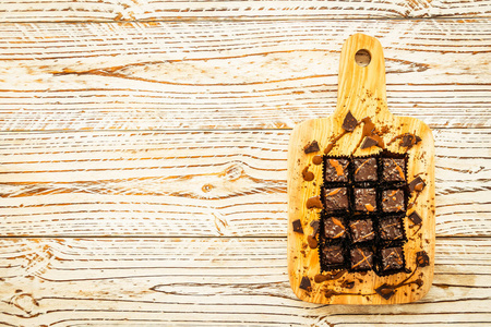 甜甜点与巧克力布朗尼蛋糕在木板切割板过滤器处理