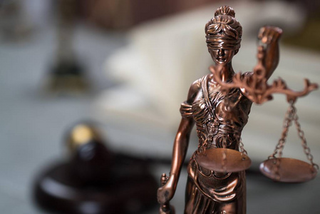法律概念   开放法律书籍用木制法官木槌在蓝色背景上法庭或法律执法办公室的桌子上。复制文本的空间