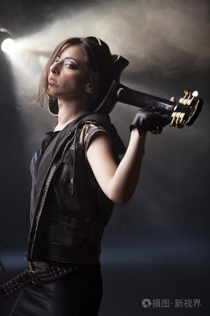 美丽的摇滚女孩摆着吉他