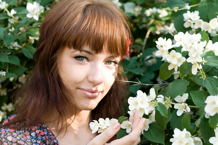 站在花丛中的一个漂亮女孩的特写肖像