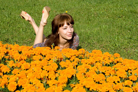 美丽的女孩躺在草地上，开着花