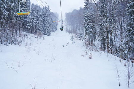 走到滑雪跑道。椅子上的电梯在积雪覆盖的树上升起