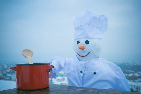 冬天的雪人厨师用厨房勺和锅