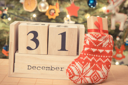 复古相片, 日期12月31日在日历, 礼物在袜子和圣诞树与装饰, 新年前夕