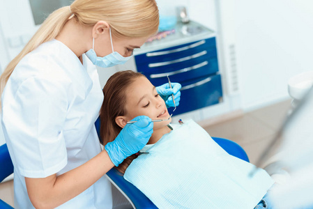 一个小女孩在接待牙医。女医生准备检查一个女孩的牙齿